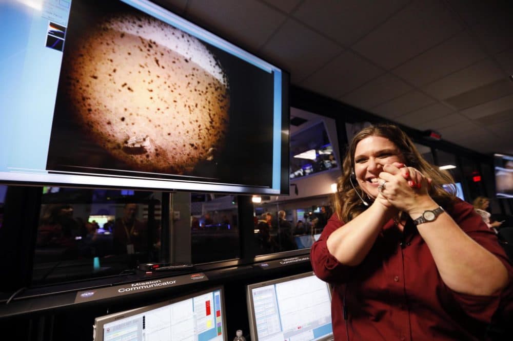 An engineer smiles next to an image of Mars sent from the InSight Lander shortly after it landed on Mars in the mission support area of the space flight operation facility at NASA's Jet Propulsion Laboratory Monday, Nov. 26, 2018, in Pasadena, Calif. (Al Seib/Los Angeles Times via AP, Pool)