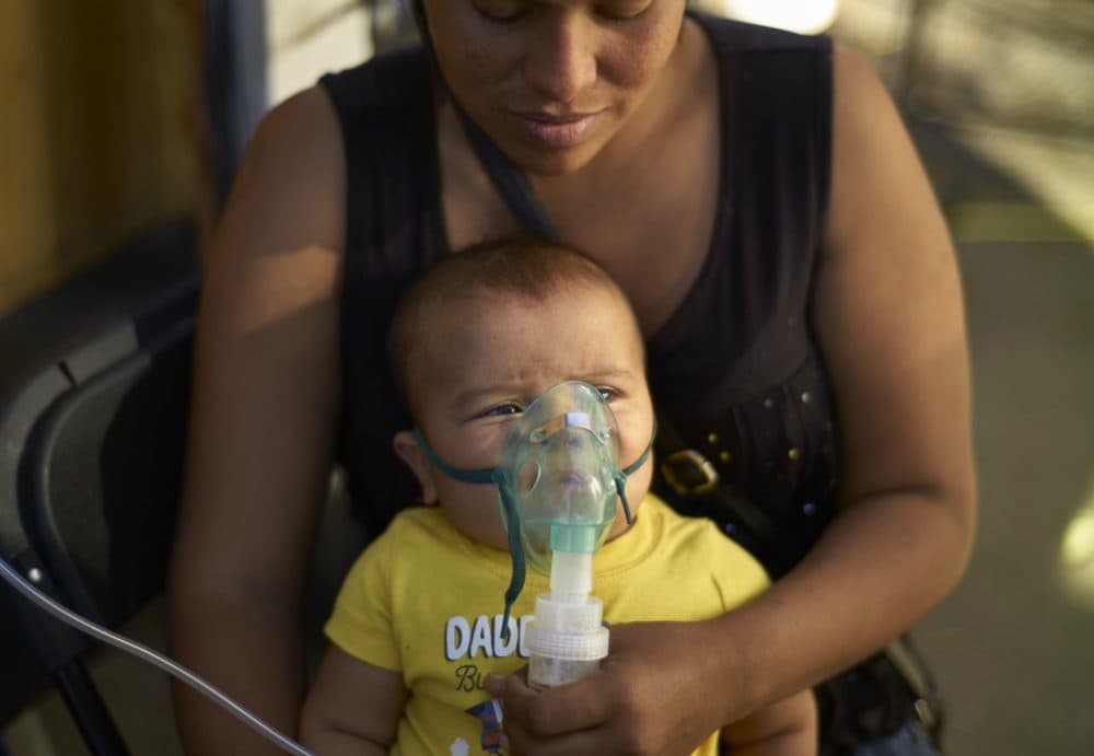 Honduran migrant Janet Zuniga holds her 5-month-old son Linder, as he receives medical treatment outside a shelter, Monday, Nov. 26, 2018, in Tijuana, Mexico. A day after a march by members of the migrant caravan turned into an attempt to breach the U.S. border with Mexico, many migrants appeared sullen, wondering whether the unrest had spoiled whatever possibilities they might have had for making asylum cases. (Gregory Bull/AP)