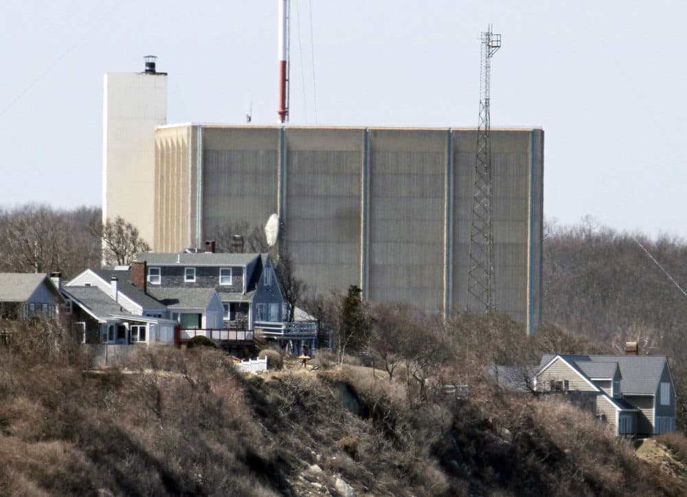 In this March 30, 2011 file photo, a portion of the Pilgrim Nuclear Power Station is visible beyond houses along the coast of Cape Cod Bay in Plymouth, Mass. (Steven Senne/AP)