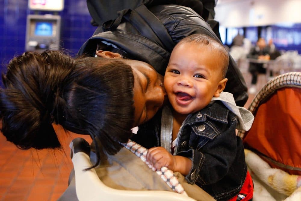 Asia Daniels gives her six-month-old son Quincy a kiss as they wait to board a bus at the Greyhound Bus Terminal in Denver on Wednesday, Nov. 21, 2012. They were on their way to Colorado Springs, Colo., to spend Thanksgiving with family. (Ed Andrieski/AP)