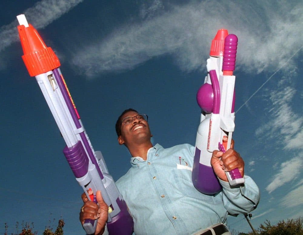 Toy inventor Lonnie Johnson poses with his creation &quot;The Super Soaker&quot; outside his Marietta, Ga., office Nov. 12, 1998. Johnson, who once worked for NASA, hit on his idea for the high-powered water gun while trying to invent a heat pump that would use water instead of Freon. (John Bazemore/AP)