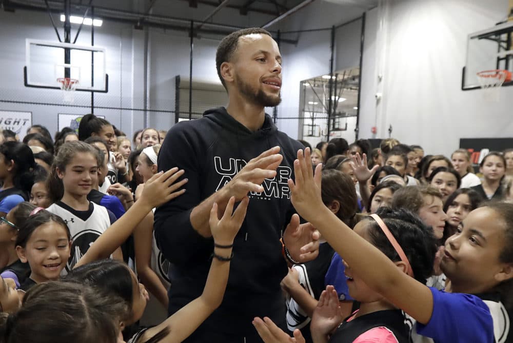 Golden State Warrior Stephen Curry greets basketball camp participants. A letter from a 9-year-old girl has helped Stephen Curry and Under Armour fix online access to his shoes for girls. (Jeff Chiu/AP)