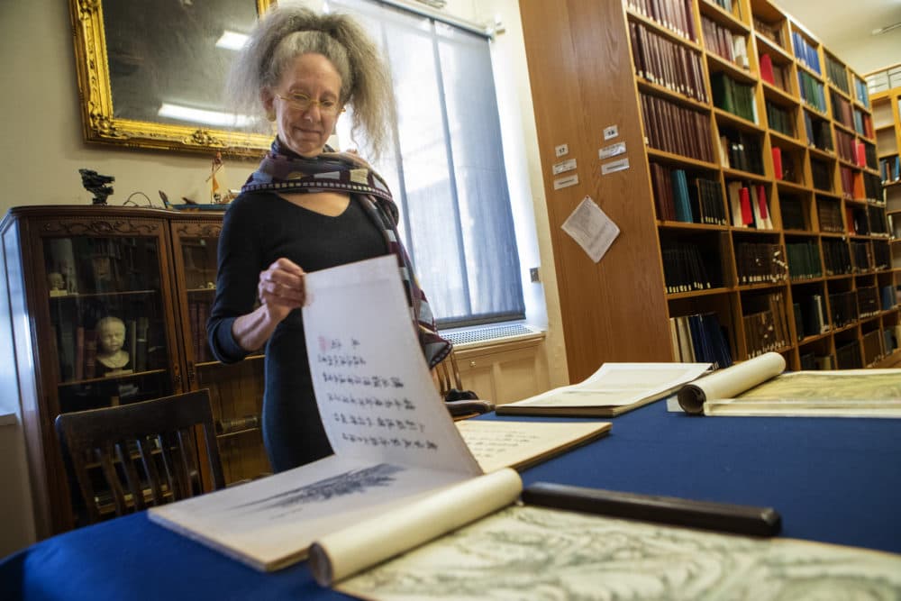 MFA curator Nancy Berliner stands over a 17th-century Chinese scroll newly given to the museum. (Jesse Costa/WBUR)
