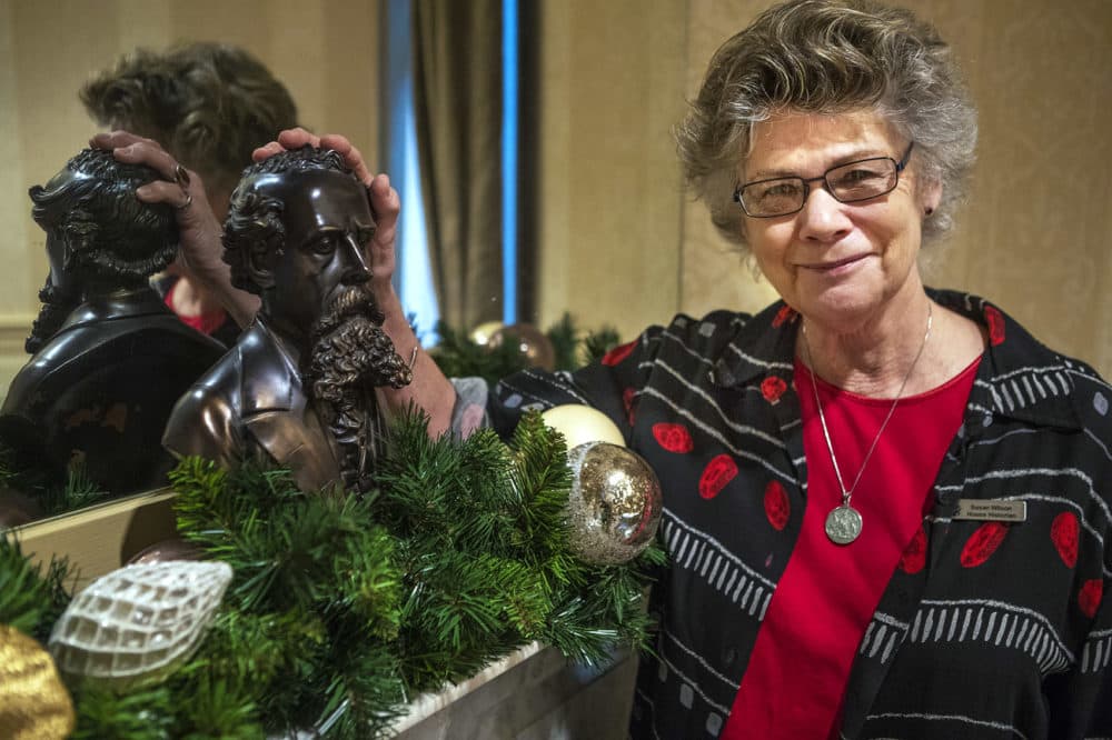 Historian Susan Wilson places her hand on a bust of Charles Dickens at the Omni Parker House, where he stayed in during his visit to Boston in 1867. (Jesse Costa/WBUR)