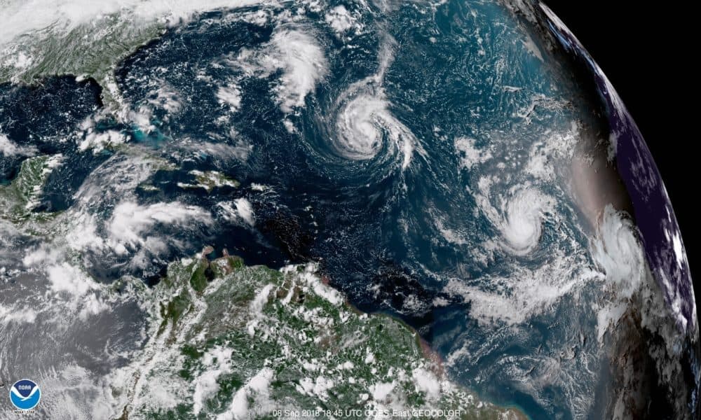 This enhanced satellite image made available by NOAA shows Tropical Storm Florence, center, in the Atlantic Ocean on Saturday, Sept. 8, 2018. (NOAA via AP)