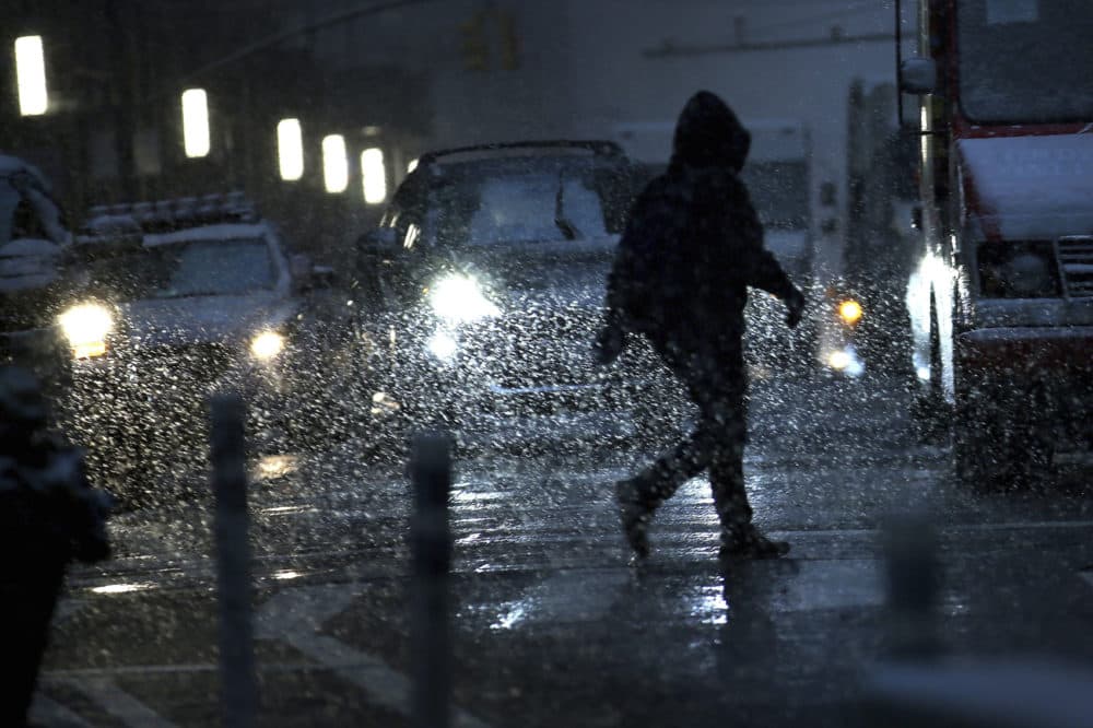A man is silhouetted by car headlights as he crosses the streets of lower Manhattan during a snow storm on Thursday, Nov. 15, 2018, in New York. (Wong Maye-E/AP)