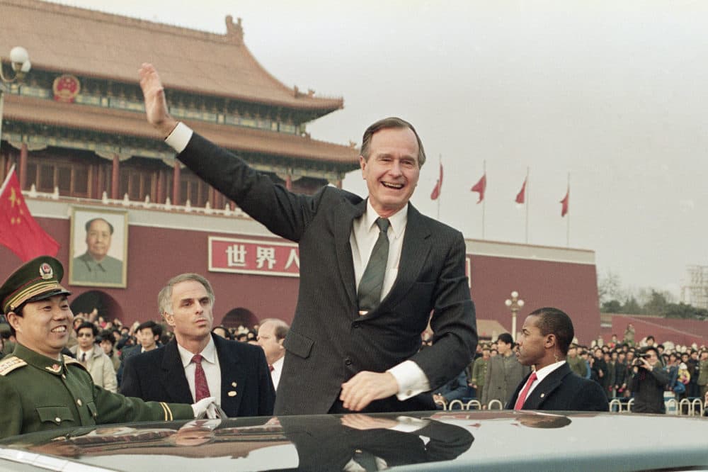 Former U.S. President George H.W. Bush stands on his car and waves to crowds in Tiananman Square in Beijing, Feb. 25, 1989. Chinese state media are praising Bush as a &quot;statesman of vision,&quot; recalling the late president's role in helping end the Cold War and establishing policies toward China. (Doug Mills, File/AP)