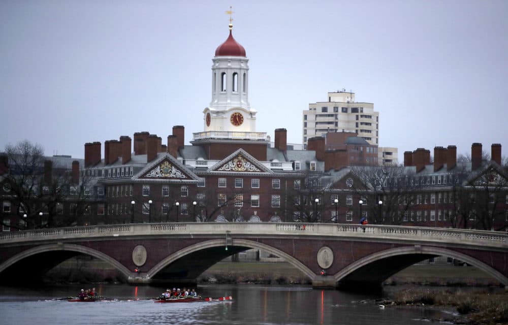 Rowers paddle down the Charles River past the campus of Harvard University in Cambridge, Mass. (Charles Krupa/AP)