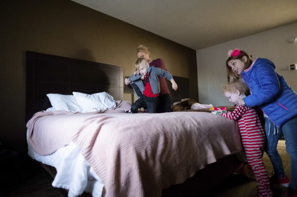 Erica Hail, back left, dresses son Vance Maloney, 5, while preparing her children for their first day of school since the Camp Fire destroyed their home, Monday, Dec. 3, 2018, in Yuba City, Calif. Jaxon Maloney, 2, second from right, and Bella Maloney, 8, right, look on. The family, who lost their five-bedroom home in Paradise, plans to stay in a hotel room through February. (Noah Berger/AP)