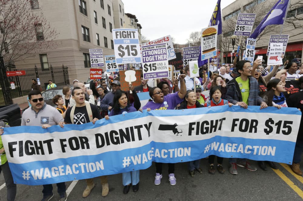 Fast-food restaurant employees and other workers marched in a &quot;Fight for 15&quot; demonstration in Boston in 2015. The Massachusetts minimum wage will rise to $12.75 per hour on Jan. 1 and gradually increase to $15 per hour in 2023. (Steven Senne/AP)