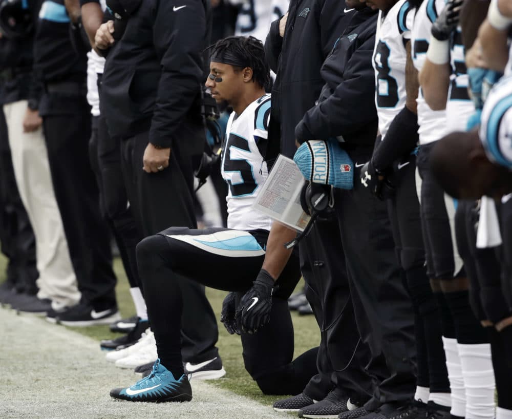 Carolina Panthers strong safety Eric Reid, center, takes a knee during the playing of the national anthem before an October game against the Philadelphia Eagles. (Matt Rourke/AP)