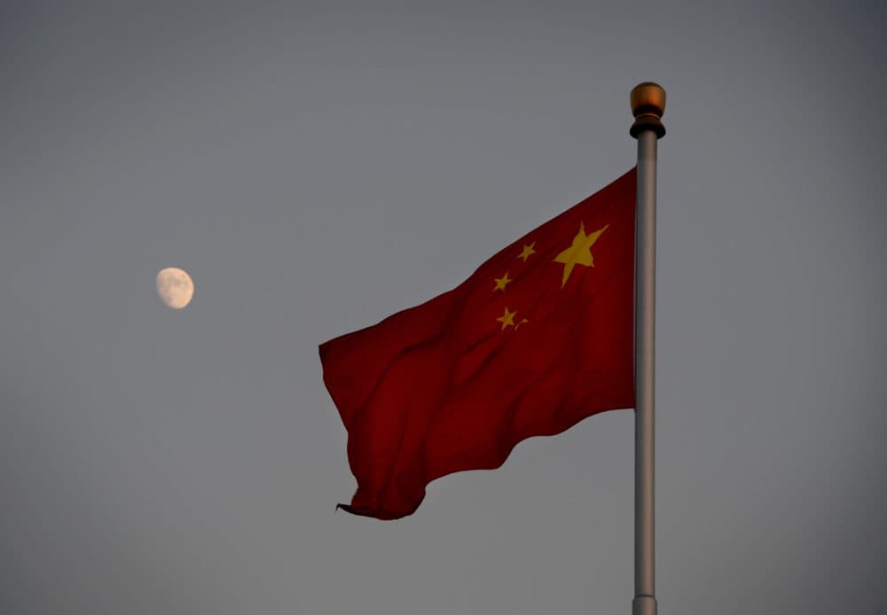 The Chinese flag is seen in front of a view of the moon at Tiananmen Square in Beijing on Dec. 13, 2013. (Mark Ralston/AFP/Getty Images)