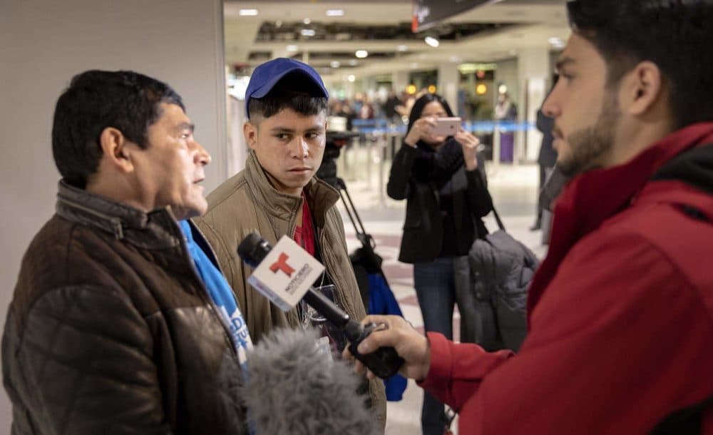 Emerson, 17, and his father, Juan, talk to the press after being reunited at Logan Airport. (Robin Lubbock/WBUR)