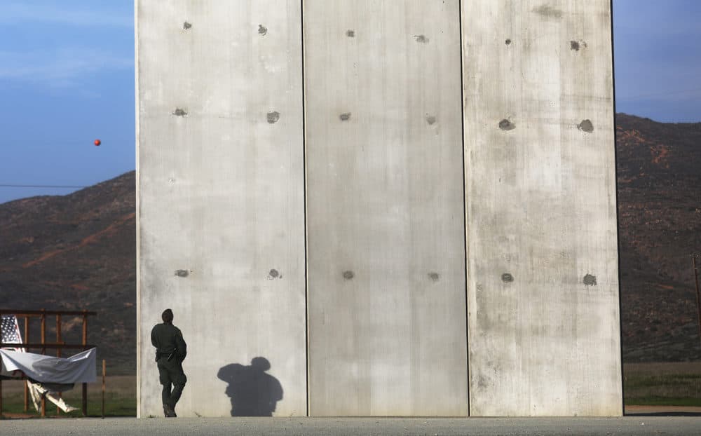 A U.S. Border Patrol agent walks toward one of President Trump's border wall prototypes on the U.S. side of the U.S.-Mexico border on Jan. 9, 2019, as seen from Tijuana, Mexico. (Mario Tama/Getty Images)