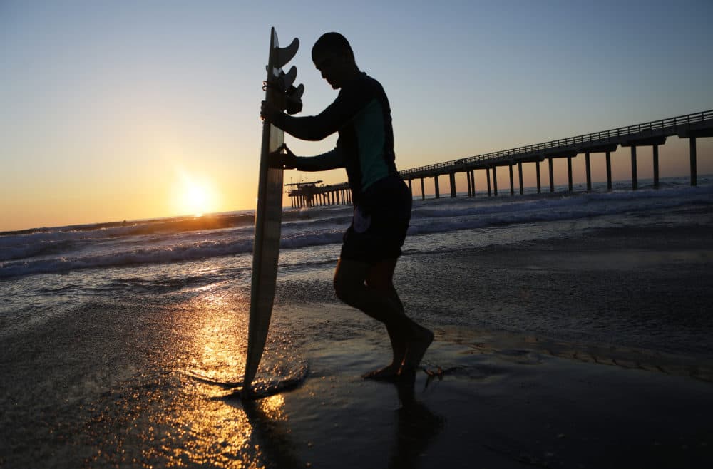 A surfer stands in front of Scripps Pier on the Pacific Ocean on Aug. 7, 2018 in San Diego, Calif. The sea surface temperature at Scripps Pier was measured at an all-time high of 78.8 degrees on Aug. 3, the warmest since record keeping began at the pier 102 years ago. (Mario Tama/Getty Images)