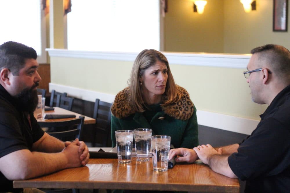 Congresswoman Lori Trahan speaks with two prison officers from FMC Devens. To her left is Jason Basil, and on her right is David Martinez. (Quincy Walters/WBUR)