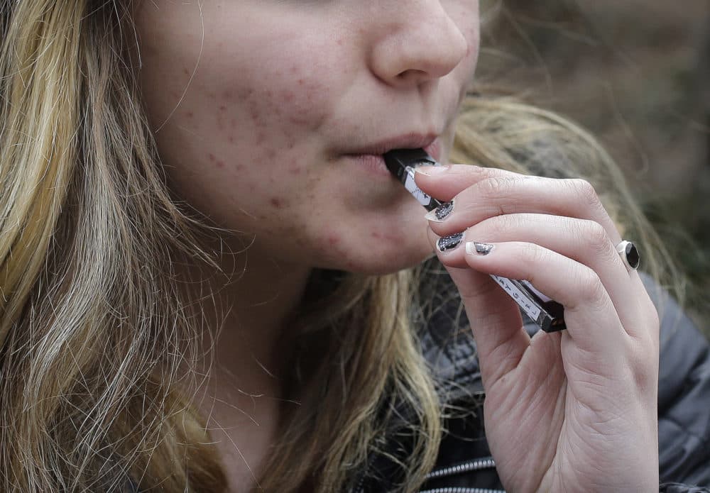 In this April 11, 2018, file photo, an unidentified 15-year-old high school student uses a vaping device near the school's campus in Cambridge, Mass. (Steven Senne/AP)