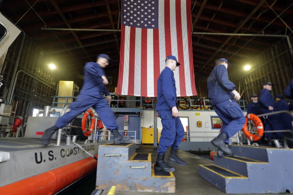 U.S. Coast Guardsmen and women, who missed their first paycheck a day earlier during the partial government shutdown, walk between 45-foot response boats during their shift at Sector Puget Sound base Wednesday, Jan. 16, 2019, in Seattle. (Elaine Thompson/AP)