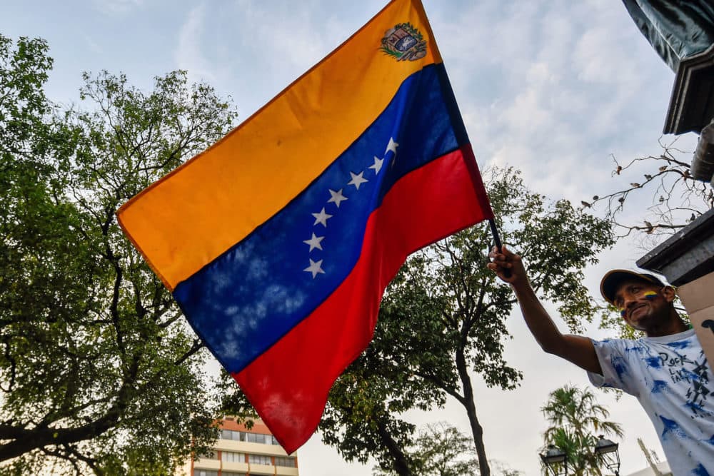 A Venezuelan holds a national flag during a protest against the government of President Nicolas Maduro at Santander square in Cucuta, Colombia, on the border with Venezuela, on Feb. 12, 2019. (Luis Robayo/AFP/Getty Images)