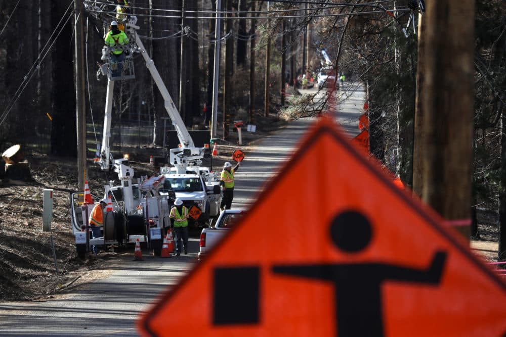 Workers make repairs to utility lines in a neighborhood that was destroyed by the Camp Fire, on Feb. 11, 2019 in Paradise, Calif. Three months after the deadly and destructive wildfire, the community is beginning the rebuilding process. (Justin Sullivan/Getty Images)