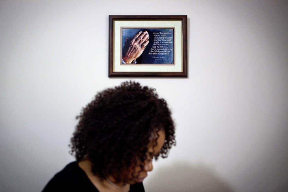 A prayer in a frame hangs on the wall as Patricia Jackson sifts through bank documents in her home Saturday, June 16, 2012, in Marietta, Ga. (David Goldman/AP)
