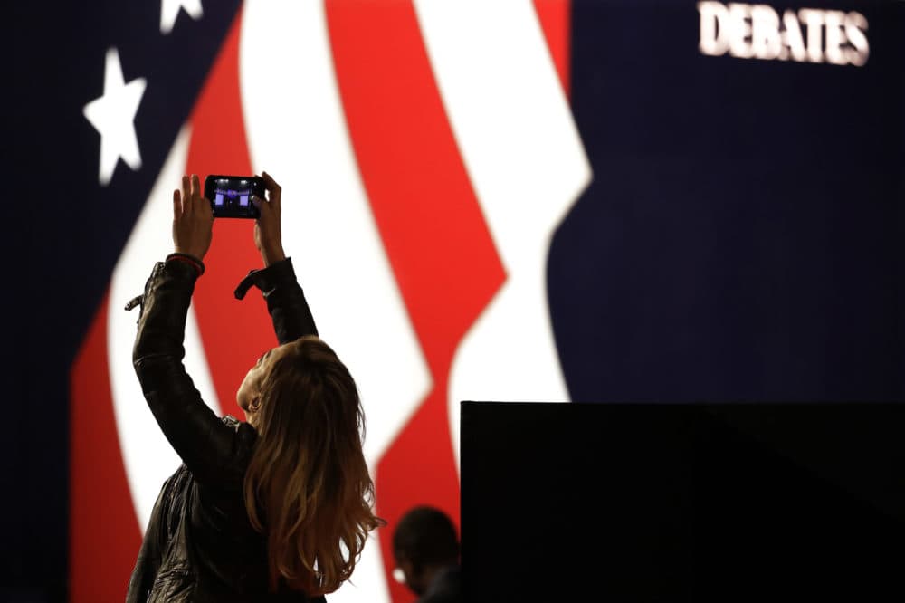 Lena Gjokaj takes a cell phone photo of stage for the presidential debate between Democratic presidential candidate Hillary Clinton and Republican presidential candidate Donald Trump at Hofstra University in Hempstead, N.Y., Monday, Sept. 26, 2016. (Julio Cortez/AP)