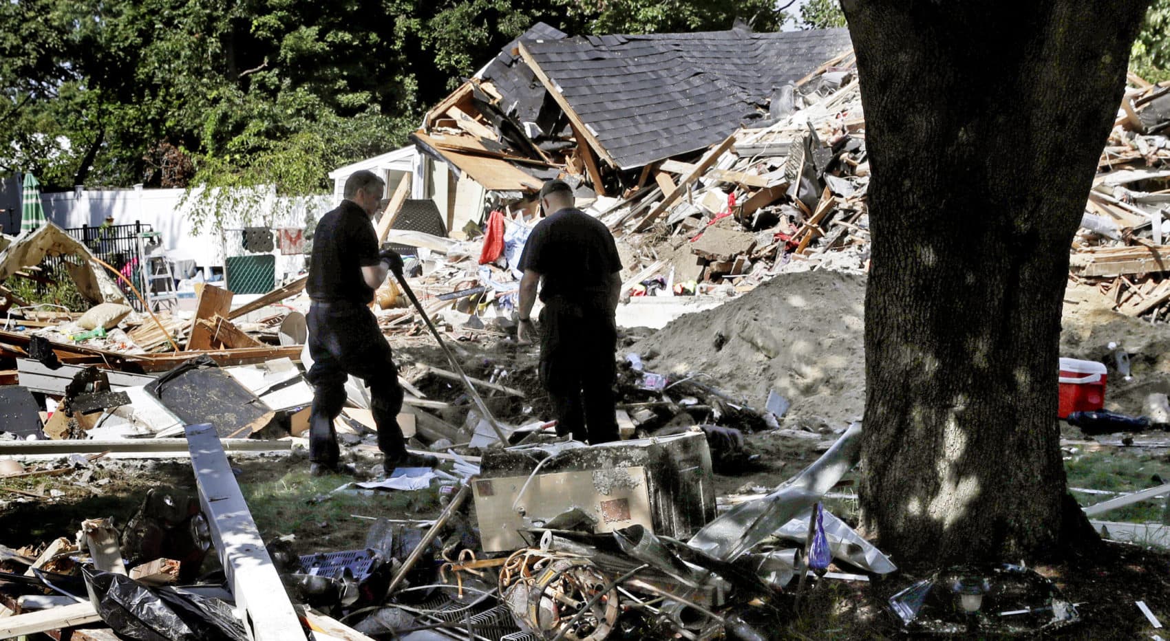 Fire investigators outside a home that exploded after the gas line failure on Sept. 13 in Lawrence. (Charles Krupa/AP)