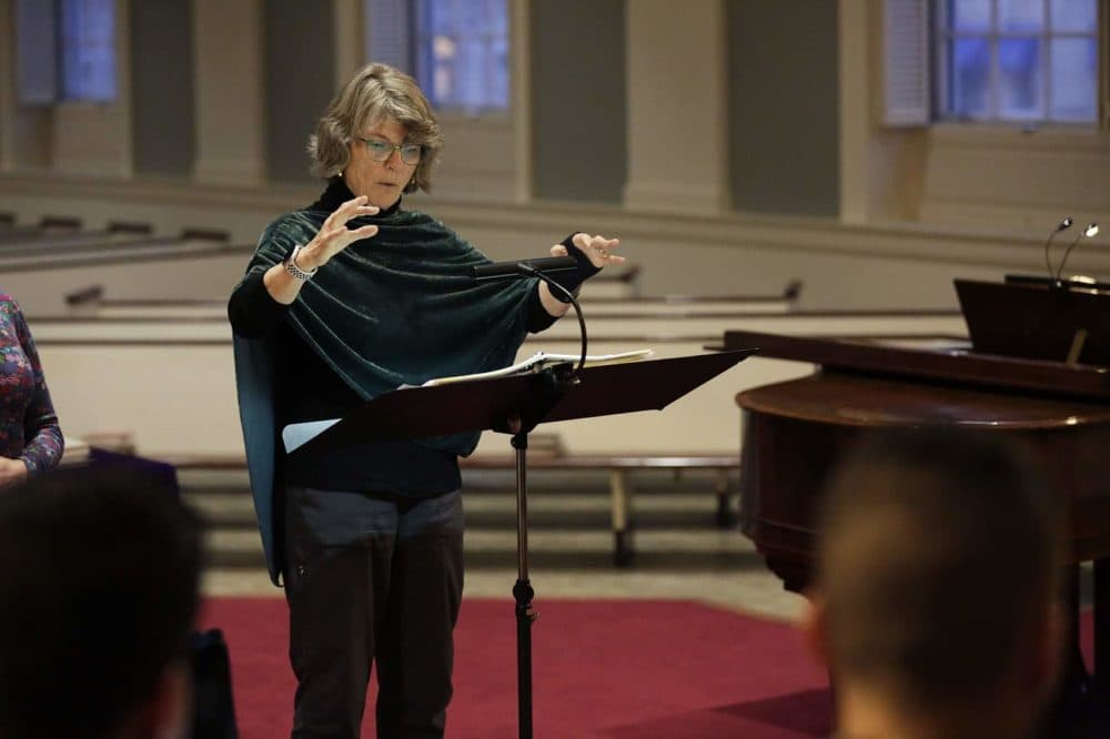 Amelia LeClair, director of Cappella Clausura, conducts a rehearsal at the Eliot Church in Newton. (Hadley Green for WBUR)