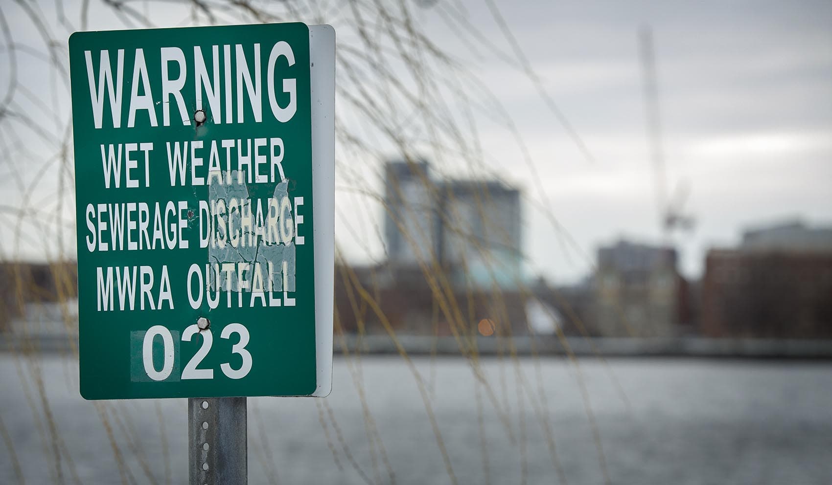 A MWRA wet weather sewage discharge outfall warning on the Charles River by the outlet of Boston's Muddy River (Robin Lubbock/WBUR)