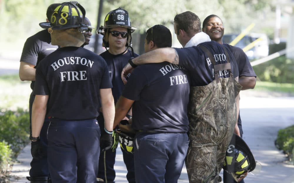 Houston firefighters gather during a door-to-door survey of a neighborhood that was hit by floodwaters from Tropical Storm Harvey in Houston on Thursday, Aug. 31, 2017. (LM Otero/AP)