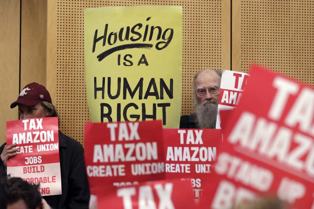 Members of the public look on at a Seattle City Council before the council voted to approve a tax on large businesses such as Amazon and Starbucks to fight homelessness in Seattle, May 14, 2018. (Elaine Thompson, File/AP)