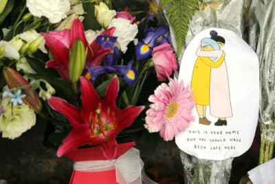 A message card is placed at a collection of flowers left at the Botanical Gardens in Christchurch, New Zealand, Saturday, March 16, 2019. (Vincent Thian/AP)