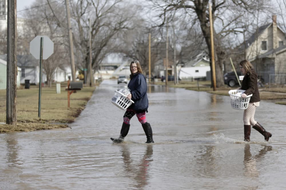 Akashi Haynes, left, and her daughter Tabitha Viers carry their belongings rescued from their flooded home in Fremont, Neb., Monday, March 18, 2019. (Nati Harnik/AP)