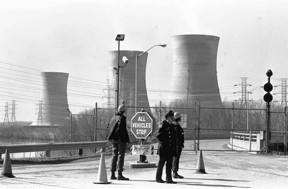 In this undated photo, a Pennsylvania state police officer and plant security guards stand outside the closed front gate to the Metropolitan Edison nuclear power plant on Three Mile Island near Harrisburg, Pa., after the plant was shut down following a partial meltdown on March 28, 1979. (Paul Vathis/AP/File)