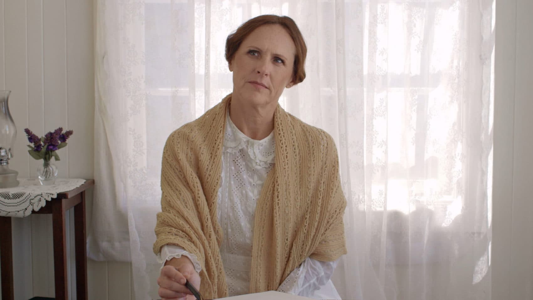 Emily (Molly Shannon) thinks at her desk, in a still from &quot;Wild Nights With Emily.&quot; (Courtesy of Greenwich Entertainment)