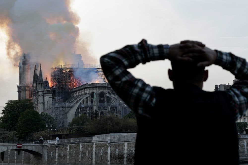 A man watches the landmark Notre Dame Cathedral burn in central Paris on April 15, 2019. (Geoffroy Van der Hasselt/AFP/Getty Images)