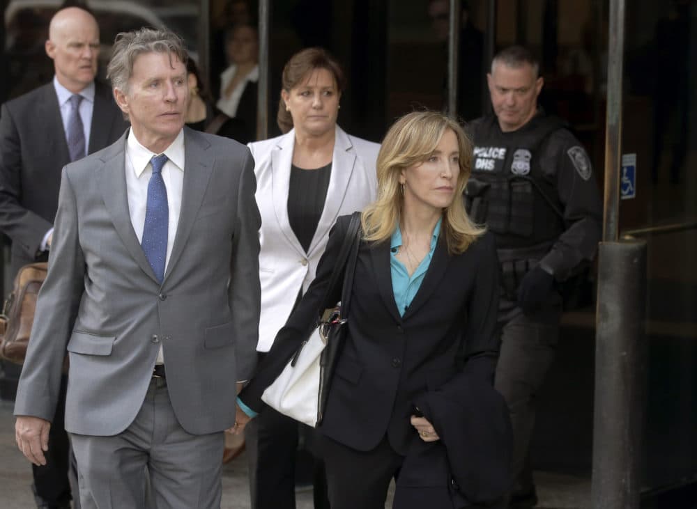Actress Felicity Huffman departs federal court in Boston with her brother Moore Huffman Jr., left, on Wednesday, April 3, 2019, after facing charges in a nationwide college admissions bribery scandal. (Steven Senne/AP)