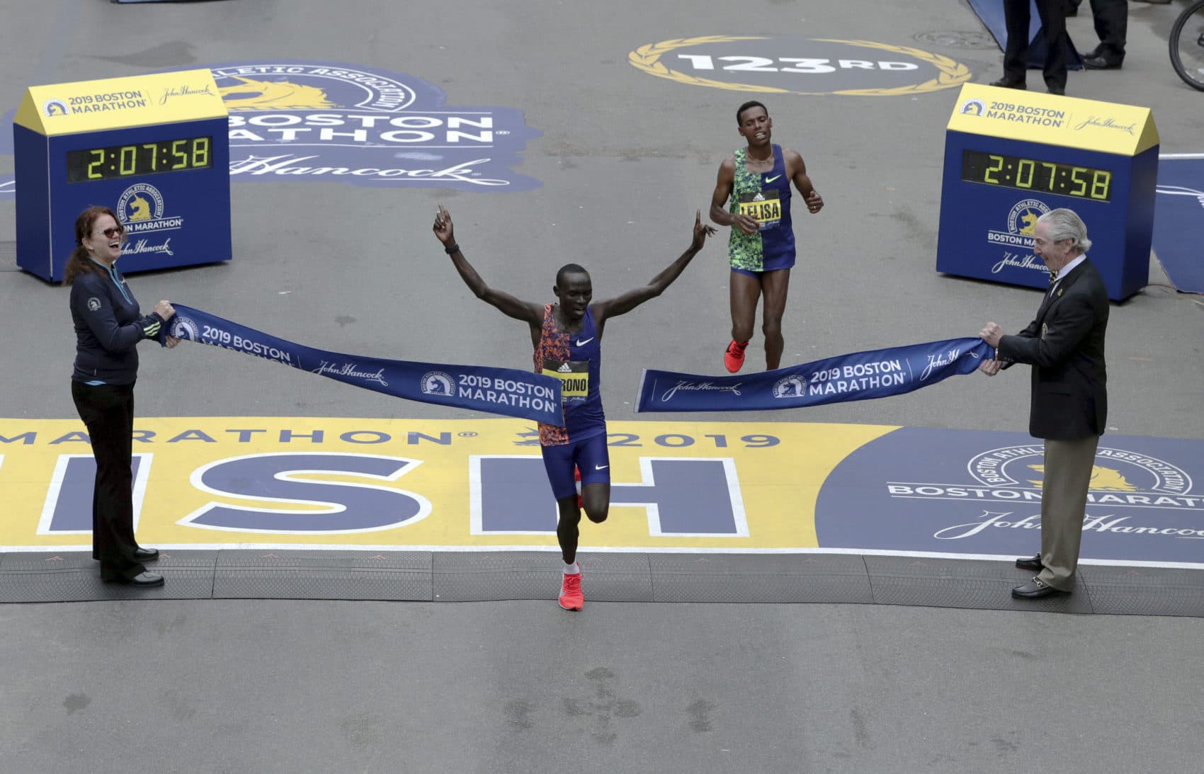 Lawrence Cherono, of Kenya, breaks the tape to win the 123rd Boston Marathon in front of Lelisa Desisa, of Ethiopia, right. (Charles Krupa/AP)