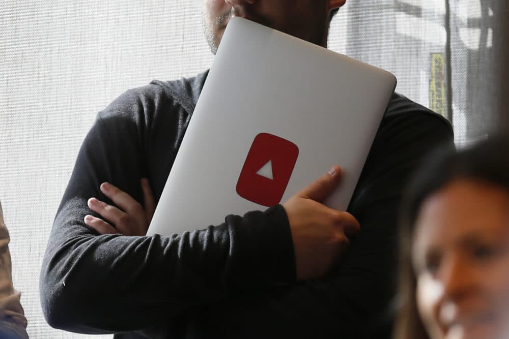A man holds a laptop computer with a YouTube logo on it at YouTube Space LA offices Wednesday, Oct. 21, 2015, in Los Angeles. (Danny Moloshok/AP)