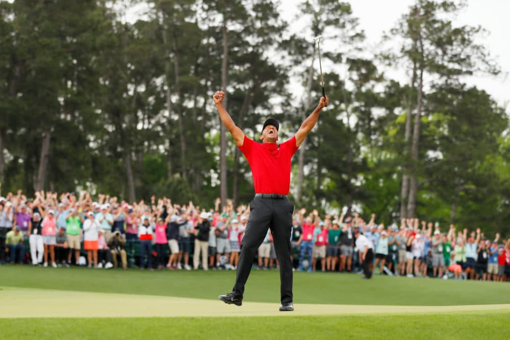 Tiger Woods celebrates after making his putt on the 18th green to win his fifth Masters title. (Kevin C. Cox/Getty Images)