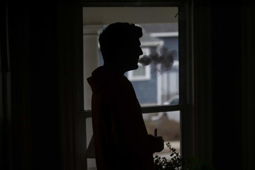 A teen uses a JUUL vaping device. (Jesse Costa/WBUR)