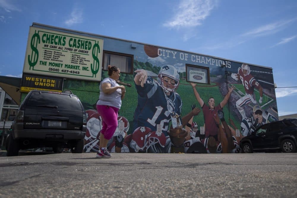 A woman walks past a mural depicting Boston as it's commonly referred to as the &quot;City of Champions.&quot; (Jesse Costa/WBUR)