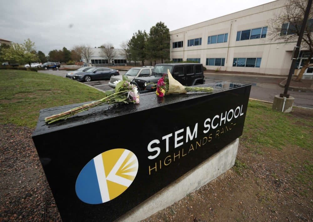 Bouquets of flowers sit on the sign outside the STEM School Highlands Ranch late Wednesday, May 8, 2019, in Highlands Ranch, Colo. A shooting took place Tuesday at the charter school south of Denver. (David Zalubowski/AP)