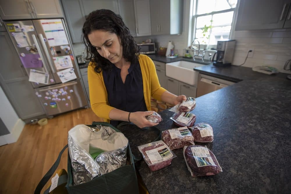 Elizabeth Pinsky checks the delivery from Walden Local, a meat share that uses locally grown and pasture-raised animals. (Jesse Costa/WBUR)