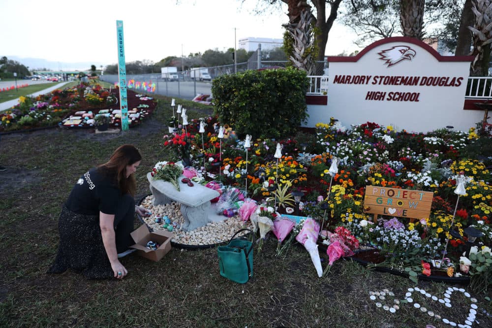 Suzanne Devine Clark visits a memorial setup at Marjory Stoneman Douglas High School for those killed during the mass shooting in Parkland, Fla. (Joe Raedle/Getty Images)
