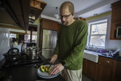 Dan slices an avocado in his kitchen. He's been on the ketogenic diet for three years now, and says it's improved his mental health and overall well-being. (Jesse Costa/WBUR)