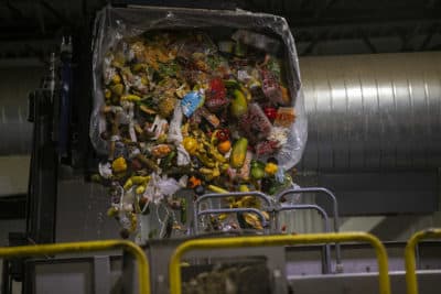 A bin of expired food from area Stop & Shop stores being poured into the anaerobic digester at the Stop & Shop Distribution Center in Freetown. (Jesse Costa/WBUR)