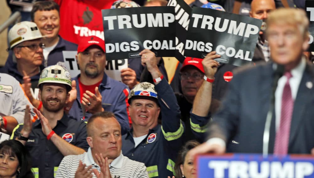 In this May 5, 2016, file photo, coal miners wave signs as then- presidential candidate Donald Trump speaks during a rally in Charleston, W.Va. (Steve Helber/AP)