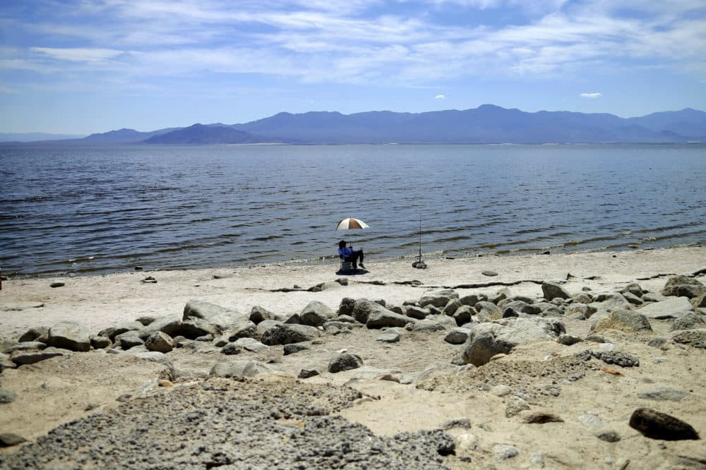 A man fishes for tilapia along the receding banks of the Salton Sea near Bombay Beach, Calif., April 30, 2015. (Gregory Bull, File/AP)