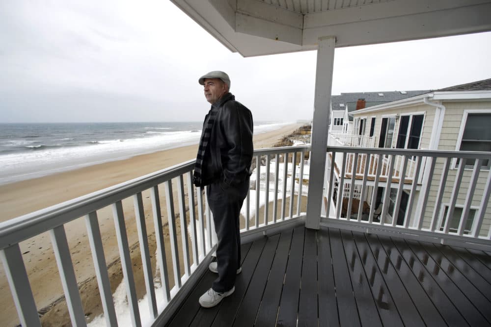 Real estate agent Tom Saab stands on a oceanfront deck at a condo he developed in Salisbury. Academic researchers say concerns over rising sea levels and increased flooding are having subtle but significant impacts on coastal property values. (Elise Amendola/AP)